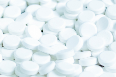 close up of white pills with a blurred background